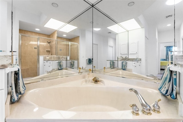 bathroom with vanity, walk in shower, and a skylight