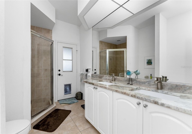 bathroom with tile patterned flooring, vanity, toilet, and a shower with shower door