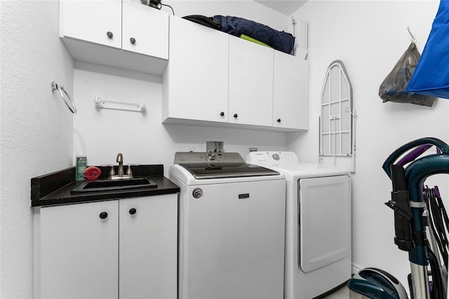 laundry area with cabinets, independent washer and dryer, and sink