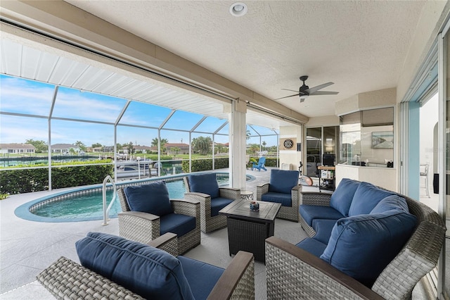 view of patio / terrace featuring an outdoor living space, ceiling fan, and a lanai