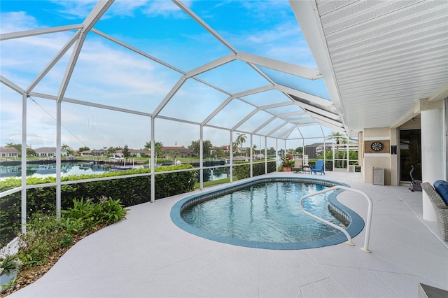 view of swimming pool with a water view, glass enclosure, and a patio area