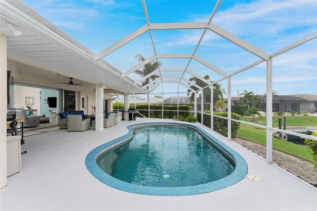 view of pool with outdoor lounge area, a patio area, ceiling fan, and glass enclosure