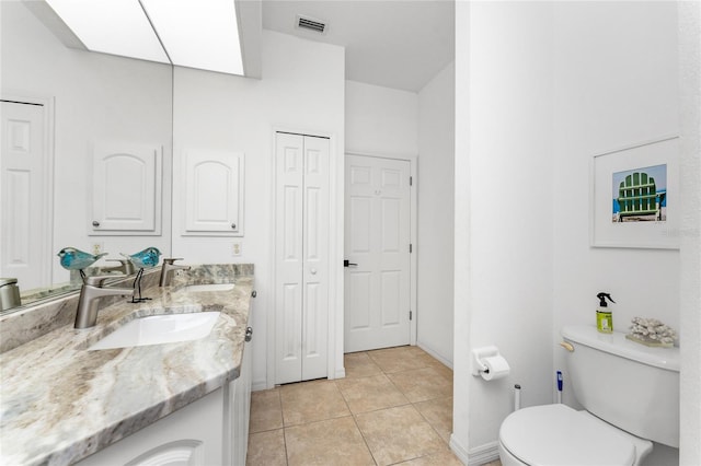 bathroom featuring tile patterned flooring, vanity, and toilet