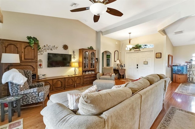 living room with lofted ceiling, ceiling fan, and light wood-type flooring