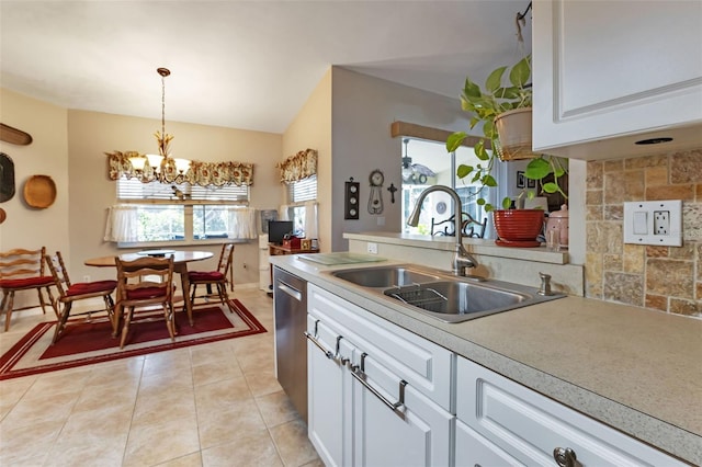 kitchen with white cabinetry, an inviting chandelier, sink, stainless steel dishwasher, and light tile patterned flooring