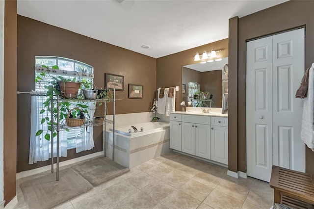 bathroom featuring tile patterned flooring, vanity, and a relaxing tiled tub