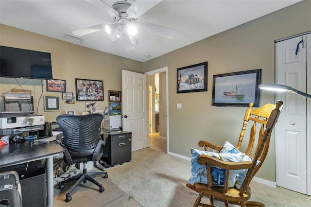 carpeted home office featuring ceiling fan