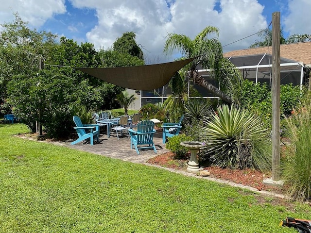 view of yard with glass enclosure and a patio area