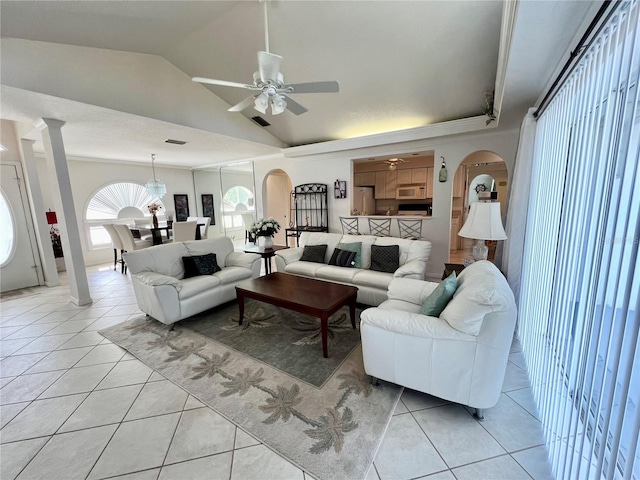 tiled living room featuring ceiling fan, vaulted ceiling, and ornate columns