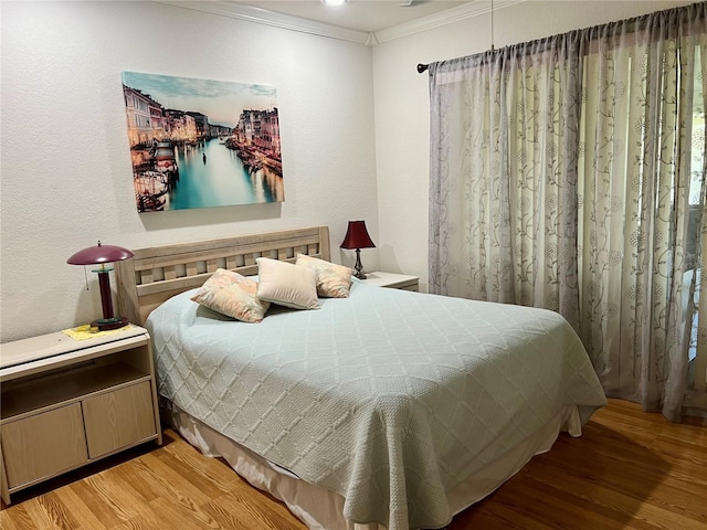 bedroom with light hardwood / wood-style flooring and ornamental molding