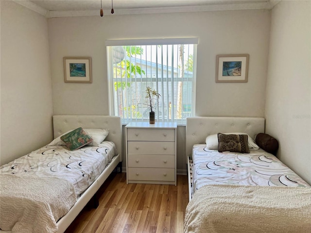 bedroom featuring crown molding and light wood-type flooring