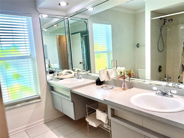 bathroom with toilet, tile patterned flooring, crown molding, vanity, and tiled shower