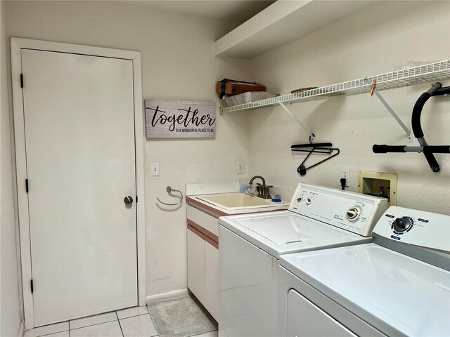 clothes washing area with light tile patterned floors, washing machine and clothes dryer, and sink