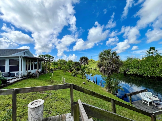 exterior space with a water view, a sunroom, and a dock