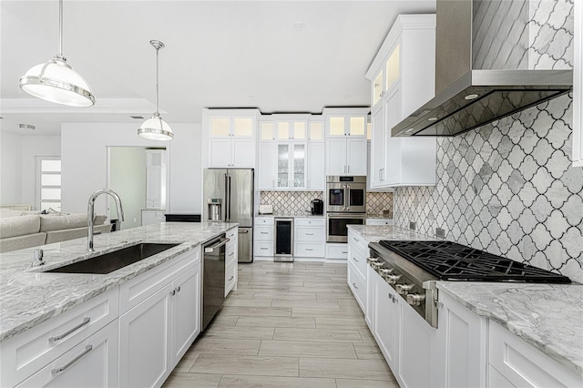 kitchen featuring beverage cooler, sink, wall chimney range hood, and white cabinets