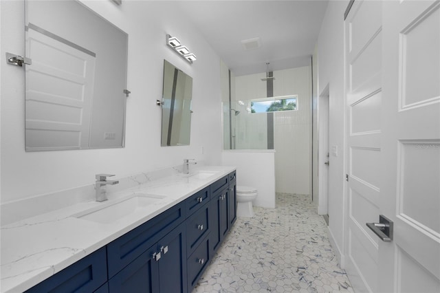 bathroom featuring vanity, toilet, a tile shower, and tile patterned floors