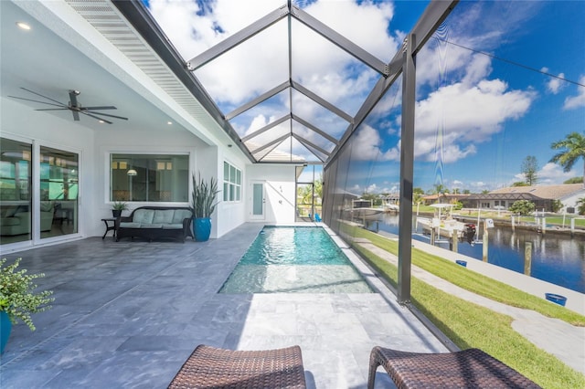 sunroom / solarium with a water view, a swimming pool, and ceiling fan