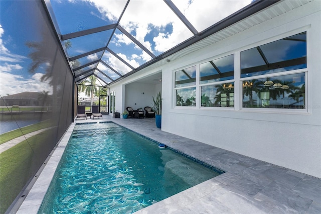 view of pool with pool water feature, a patio area, and glass enclosure