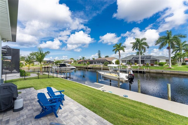 exterior space featuring glass enclosure, a lawn, and a water view