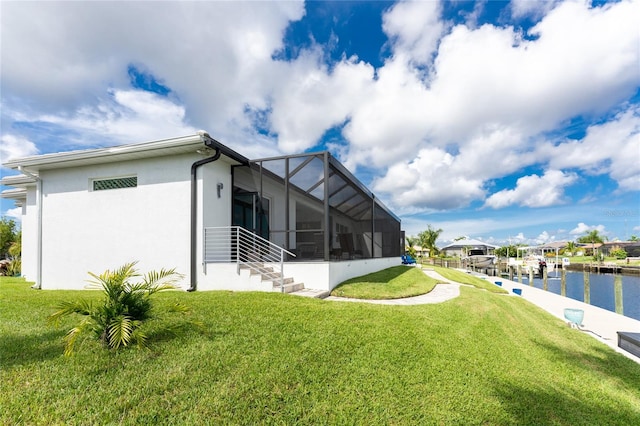 exterior space with a yard, a water view, and a lanai