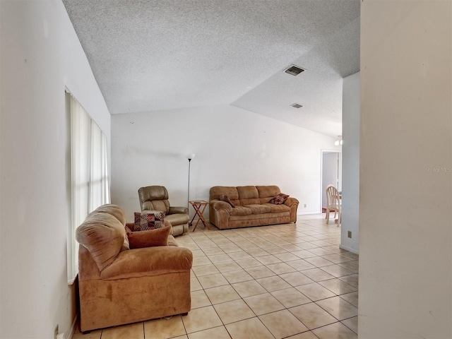 living room with light tile patterned floors, a textured ceiling, and lofted ceiling