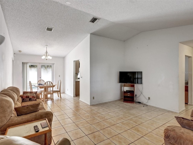 tiled living room featuring a textured ceiling, lofted ceiling, and a notable chandelier