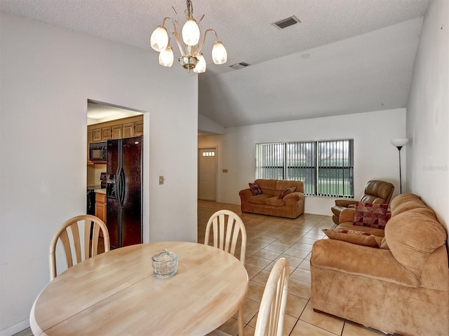 tiled dining area with a notable chandelier, lofted ceiling, and a textured ceiling