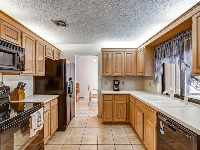 kitchen with sink, light tile patterned floors, and black appliances