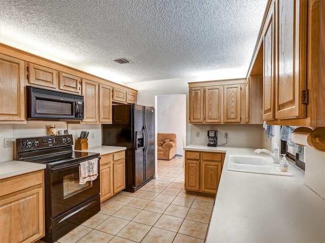 kitchen featuring light tile patterned floors, sink, and black appliances