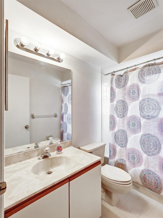 bathroom featuring tile patterned flooring, vanity, and toilet