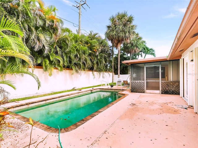 view of swimming pool with a patio and a sunroom