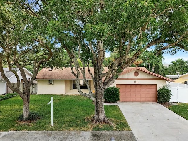 ranch-style house featuring a garage and a front lawn