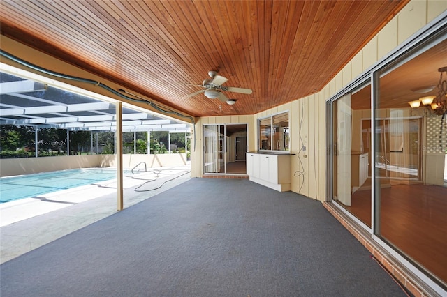 exterior space featuring a fenced in pool, glass enclosure, and a ceiling fan