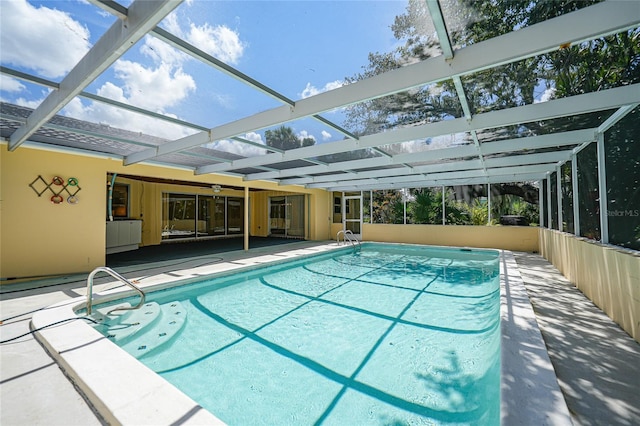 outdoor pool with glass enclosure and a patio area