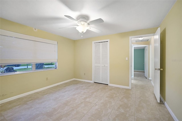 unfurnished bedroom with ceiling fan, baseboards, and a closet