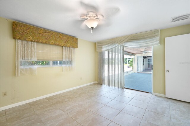 empty room with ceiling fan and light tile patterned flooring