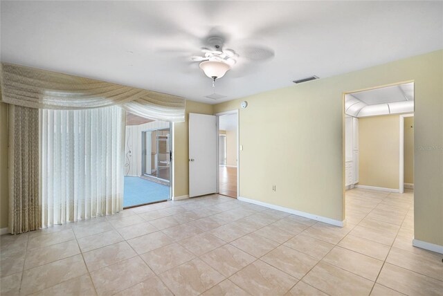 tiled spare room featuring ceiling fan