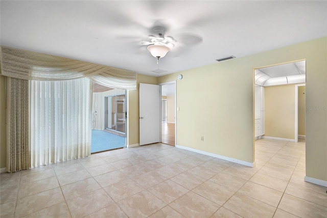 empty room featuring light tile patterned floors, visible vents, and baseboards