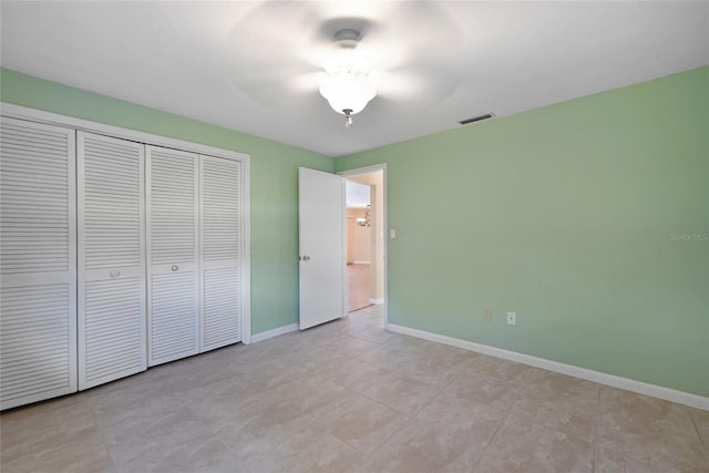 unfurnished bedroom featuring a ceiling fan, a closet, visible vents, and baseboards