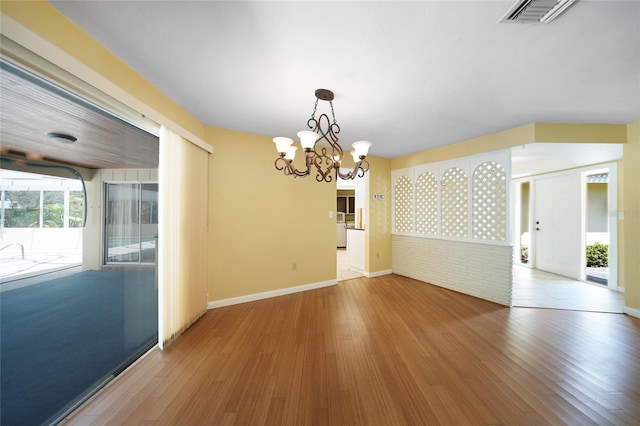 unfurnished dining area with hardwood / wood-style floors and a chandelier