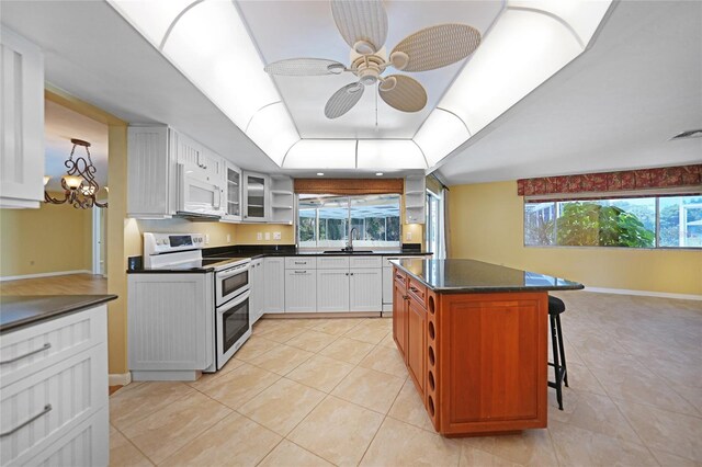 kitchen featuring white cabinets, white appliances, and light tile patterned flooring