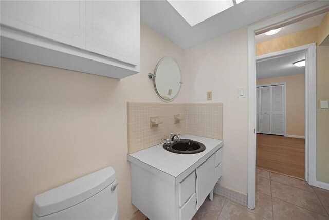 bathroom with vanity, toilet, decorative backsplash, and tile patterned flooring