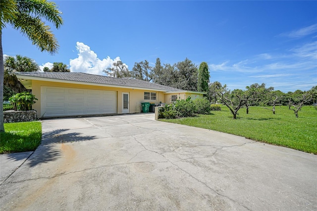 ranch-style home featuring a garage, driveway, a front lawn, and stucco siding