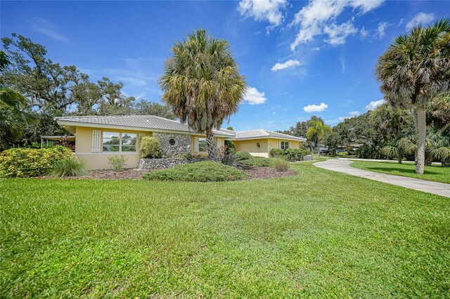 single story home featuring a front lawn