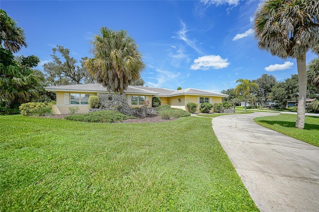 single story home with a front lawn, concrete driveway, and stucco siding