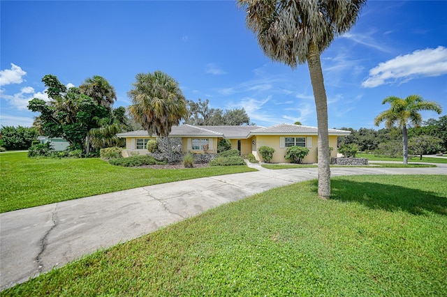 single story home with driveway, a front lawn, and stucco siding