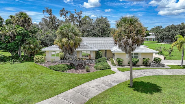 single story home featuring a front lawn, a tile roof, and stucco siding