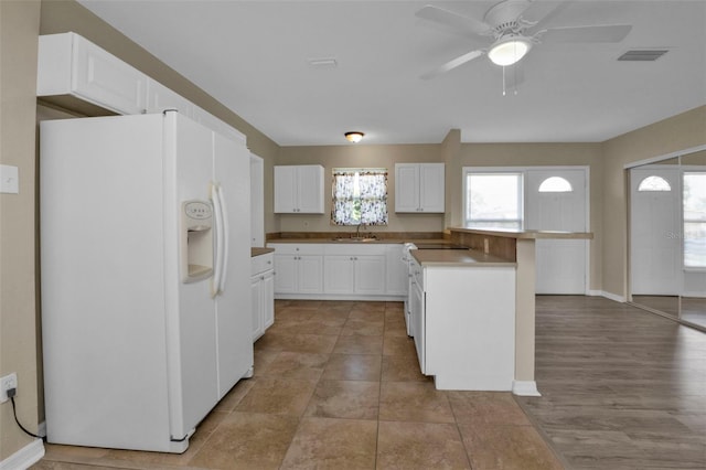 kitchen with light hardwood / wood-style floors, white refrigerator with ice dispenser, sink, white cabinets, and ceiling fan