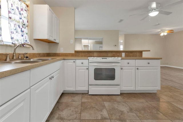 kitchen featuring sink, white cabinets, kitchen peninsula, white range with electric stovetop, and ceiling fan