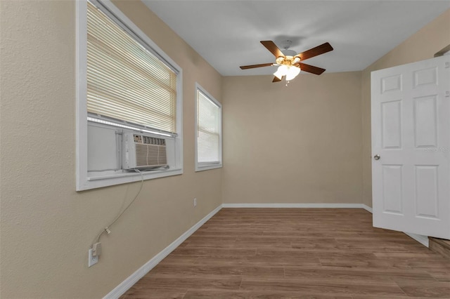 unfurnished bedroom with ceiling fan, cooling unit, and hardwood / wood-style floors